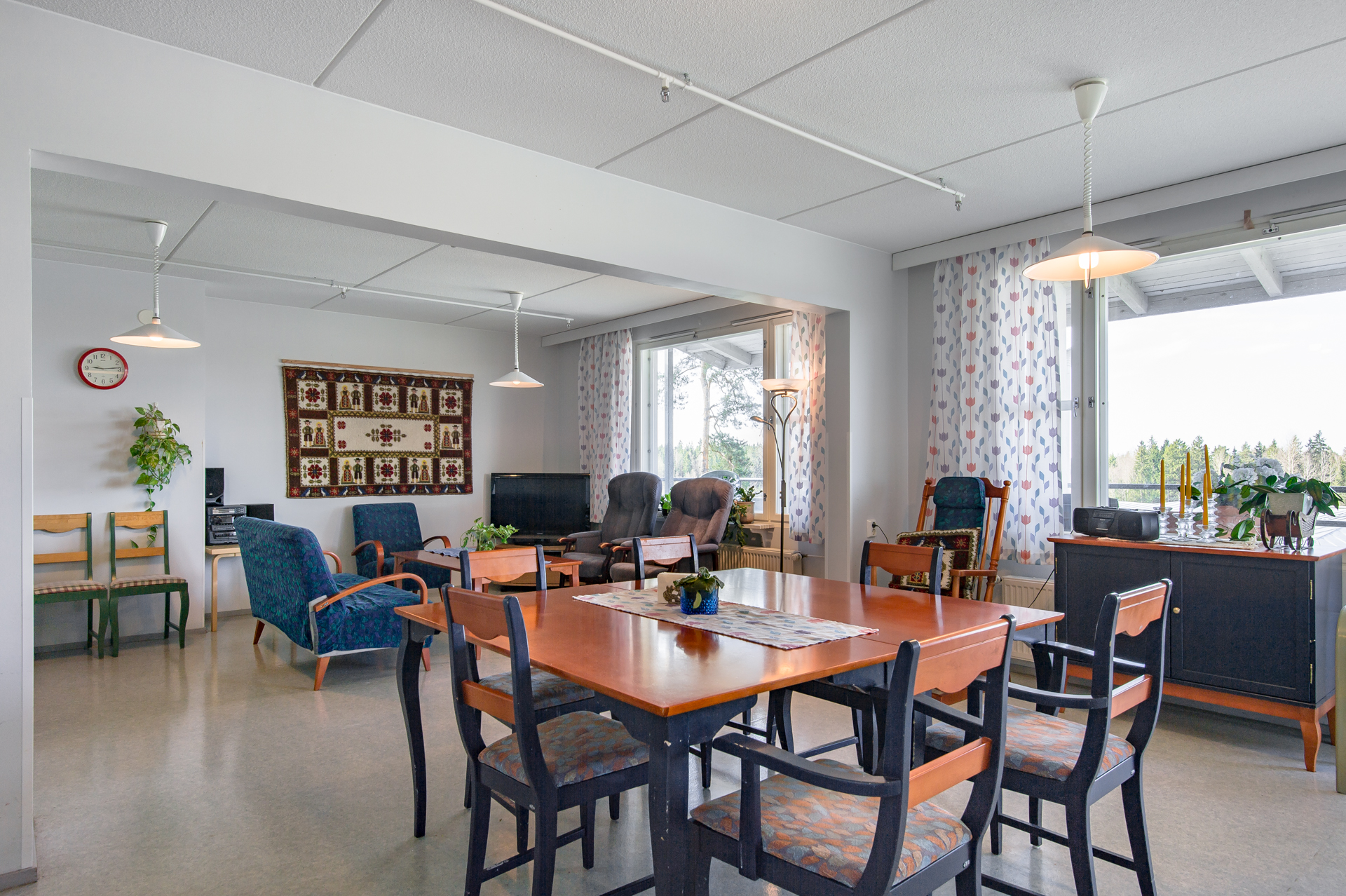 Gemensamt allrum med matbord, stolar och sittgrupp.